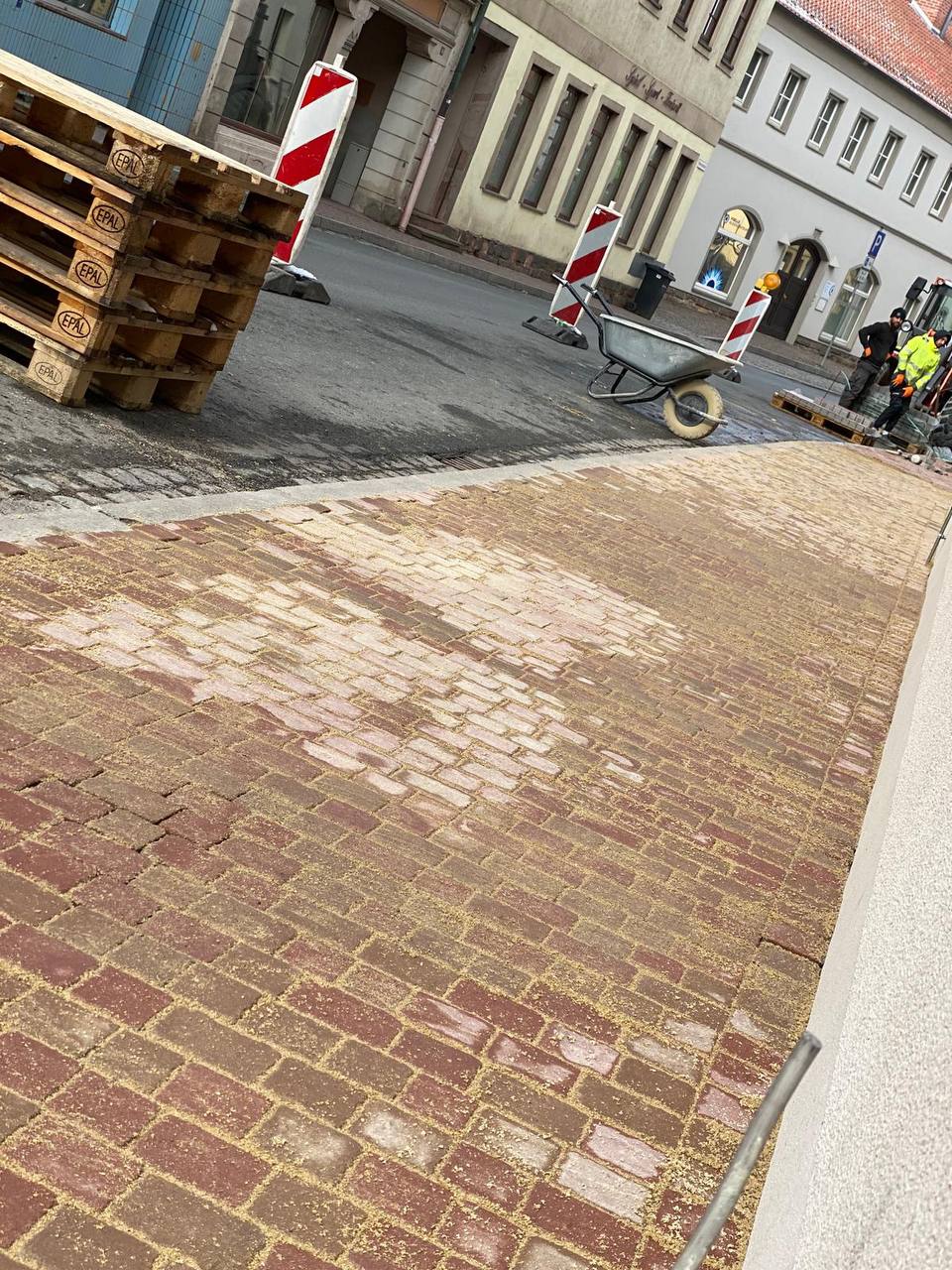 Granitpflaster und Betonrinnen in einer Dorfstraße eingebaut